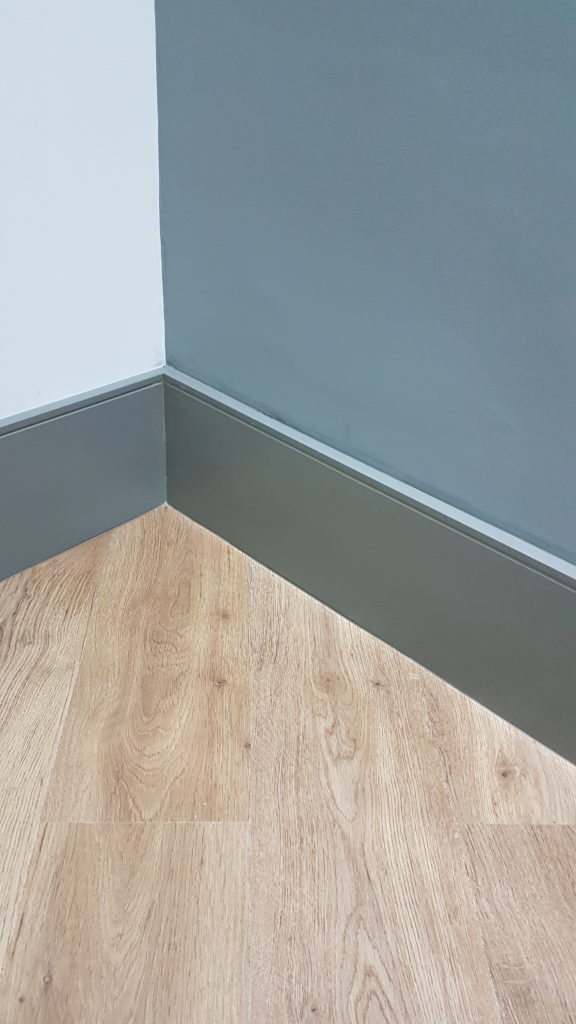 Detalhe do acabamento entre piso vinílico e rodapé